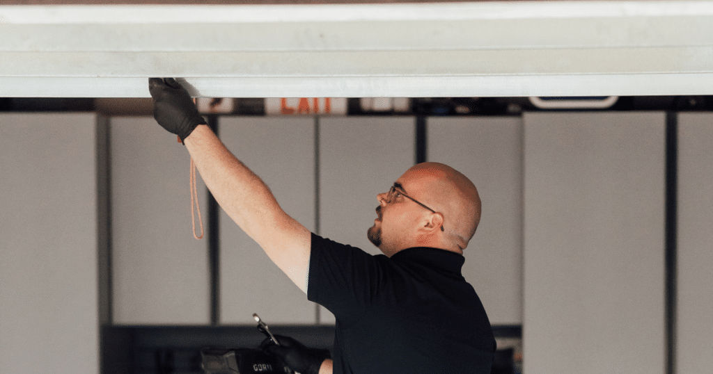 Technician fixing a garage door opener.