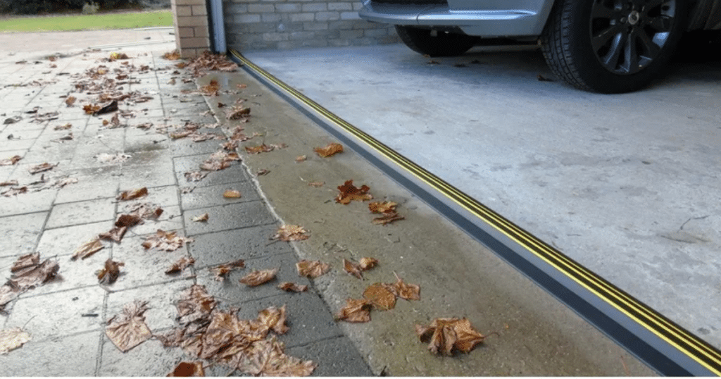 Garage floor sealed with yellow-black threshold.